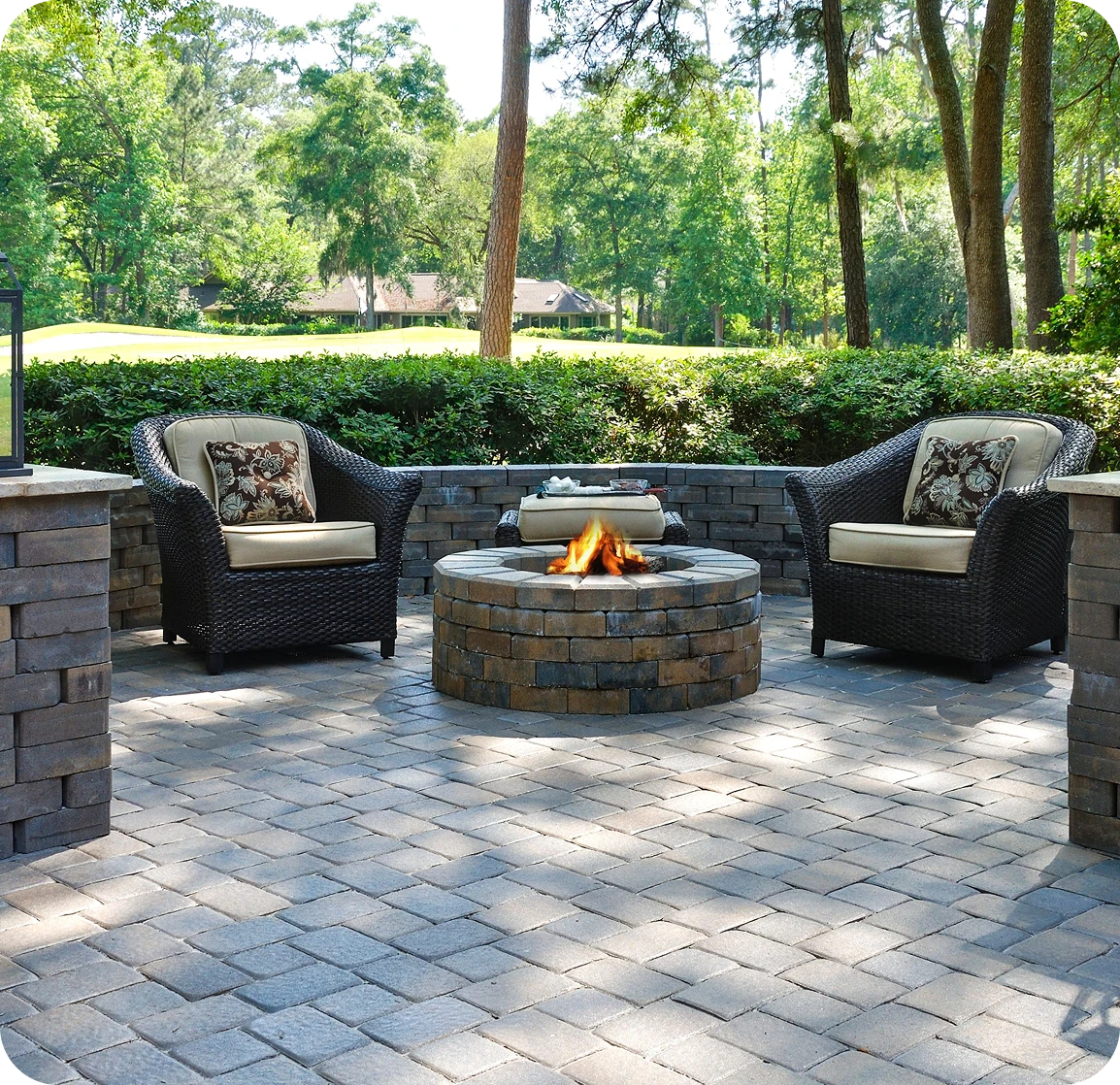 Outdoor stone patio featuring a fire pit surrounded by comfortable patio chairs